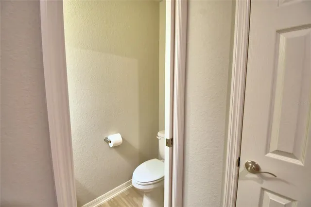 a view of a dining room with furniture a kitchen and chandelier