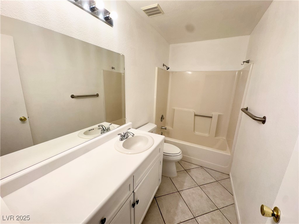 2064 Mesquite Lane, Unit 102 Laughlin, NV 89029 - Photo 11 of 22 Bathroom with toilet, vanity, tile patterned floors, and tub / shower combination