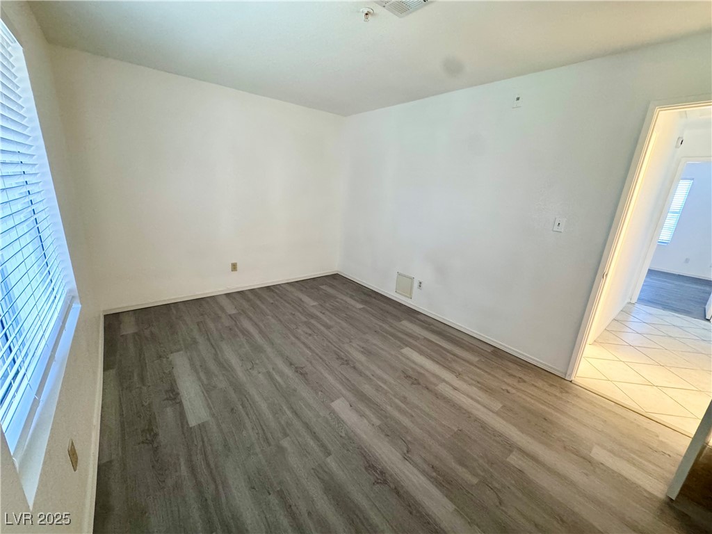 2064 Mesquite Lane, Unit 102 Laughlin, NV 89029 - Photo 14 of 22 Empty room with wood finished floors, baseboards, and fire sprinkler in ceiling