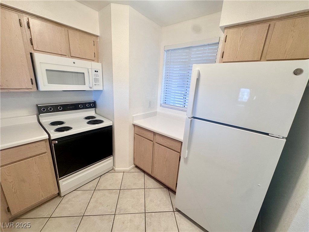 2064 Mesquite Lane, Unit 102 Laughlin, NV 89029 - Photo 2 of 22 Kitchen featuring white appliances, light countertops, and light tile patterned floors