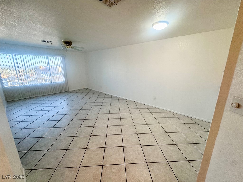 2064 Mesquite Lane, Unit 102 Laughlin, NV 89029 - Photo 5 of 22 Unfurnished room with ceiling fan, a textured ceiling, and light tile patterned floors