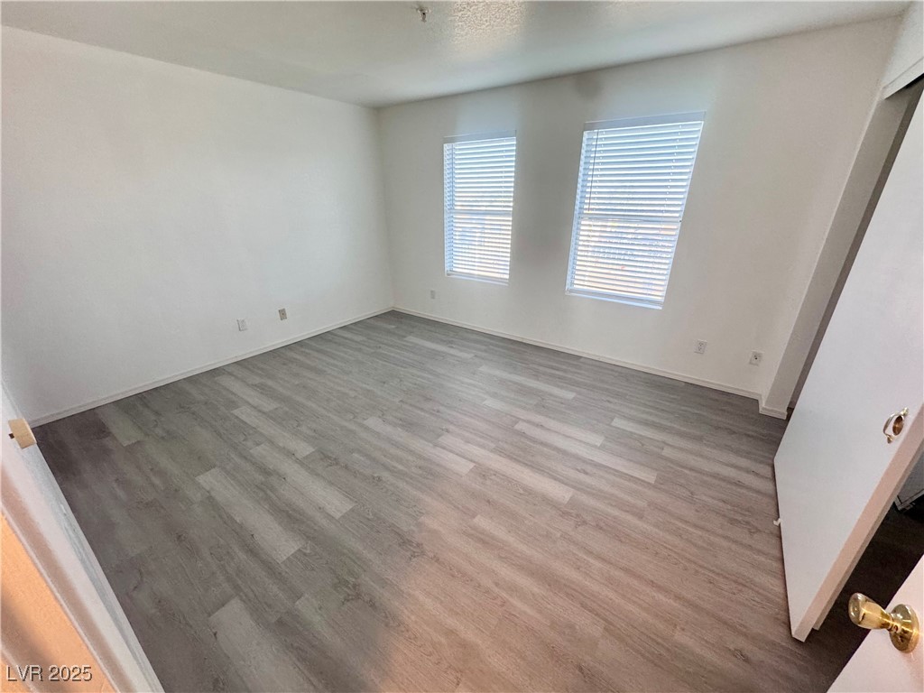 2064 Mesquite Lane, Unit 102 Laughlin, NV 89029 - Photo 9 of 22 Empty room with wood finished floors and baseboards