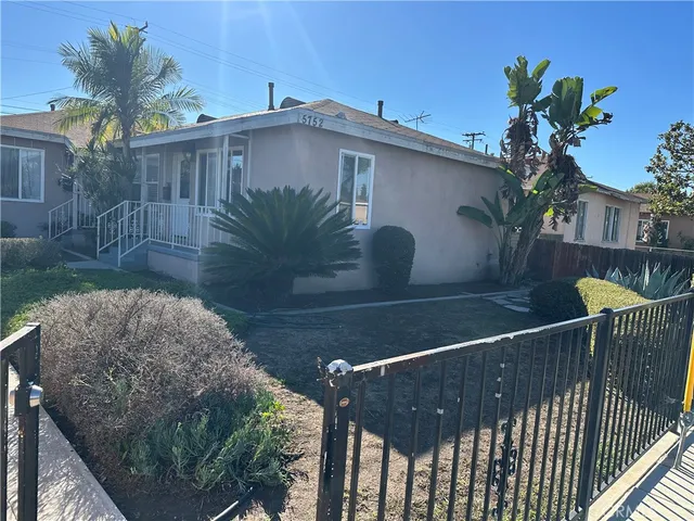 a view of a roof deck with table and chairs with wooden fence
