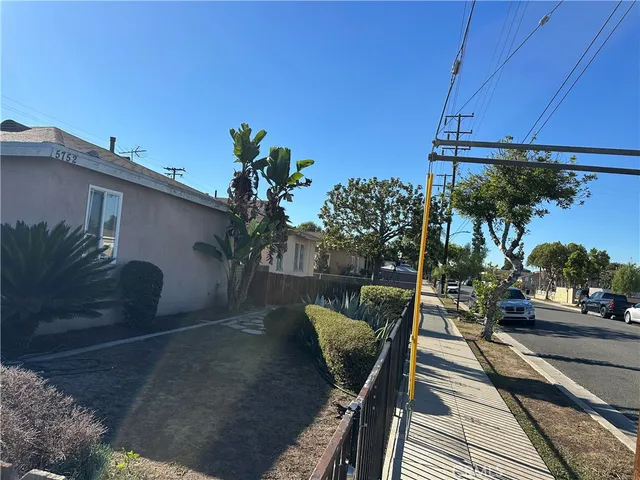 a view of a balcony with chairs and a potted plant