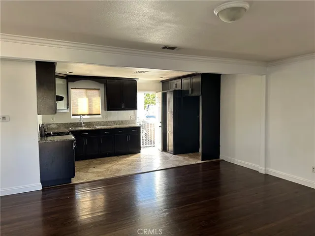 a view of kitchen with granite countertop stainless steel appliances counter space and wooden floor