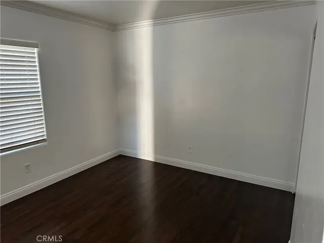 a view of a small space with wooden floor and a window