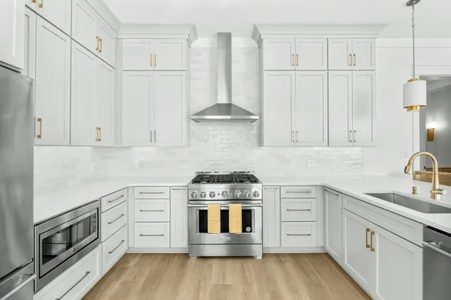a kitchen with white cabinets and appliances