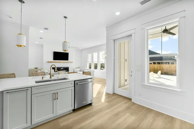 a view of kitchen with stainless steel appliances granite countertop a sink and dishwasher with wooden floor