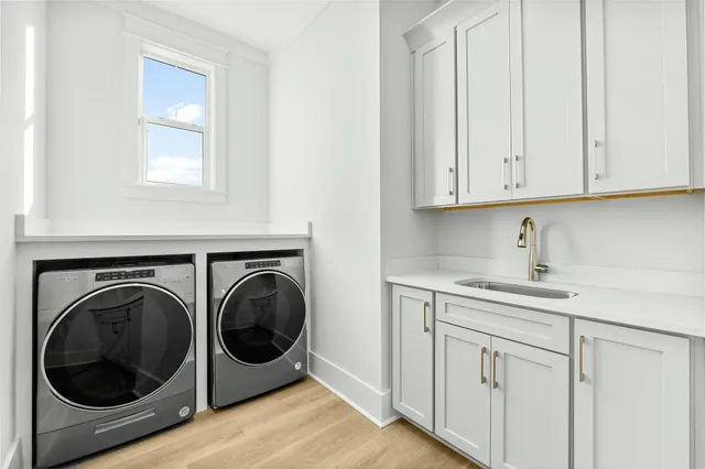 a utility room with sink dryer and washer