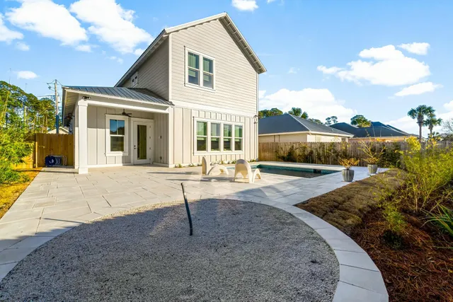 a view of a house with backyard and sitting area