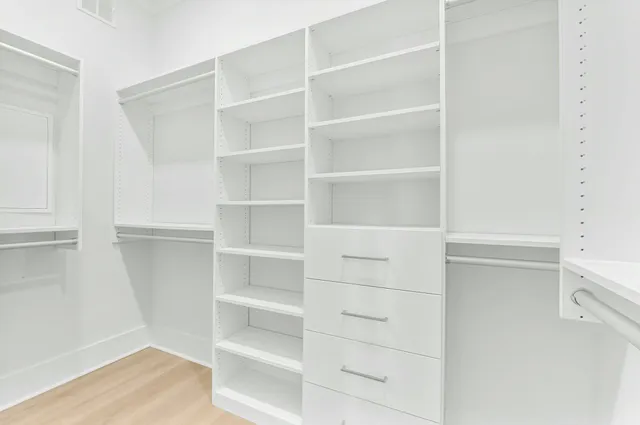 a view of walk in closet with empty racks