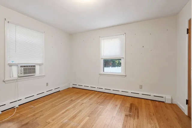 a view of a room with wooden floor and window