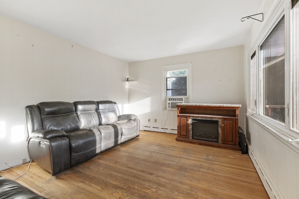 150 Gilbert Street Mansfield, MA 02048 - Photo 10 of 41 a living room with furniture a fireplace and a wooden floor