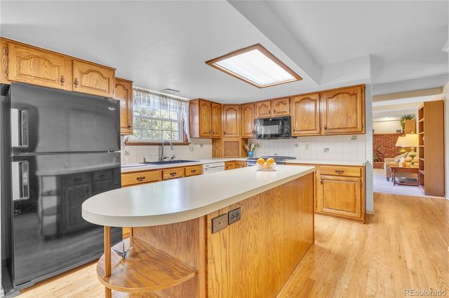 a kitchen with stainless steel appliances granite countertop a sink a stove and a refrigerator