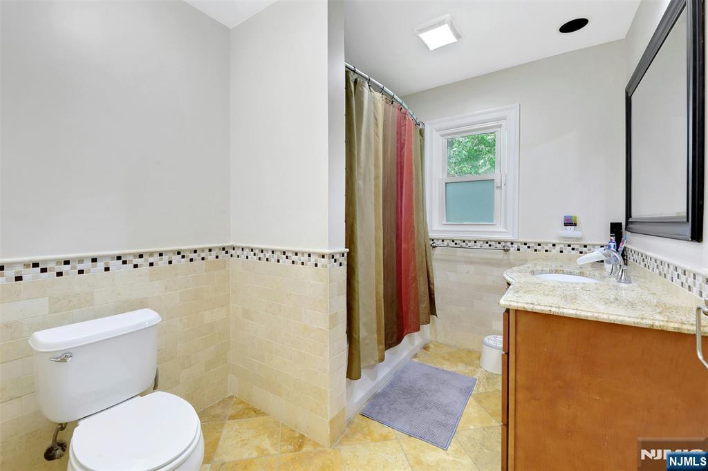 514 Rutland Avenue Teaneck, NJ 07666 - Photo 20 of 40 a bathroom with a granite countertop sink and a toilet