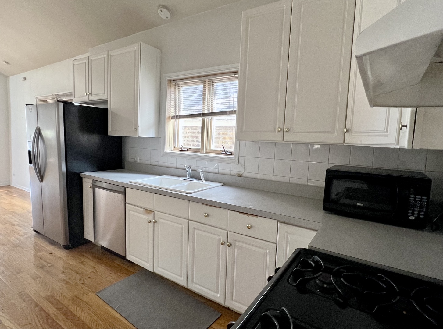 1238 North Cleaver Street, Unit 3 Chicago, IL 60642 - Photo 3 of 16 a kitchen with white cabinets and refrigerator