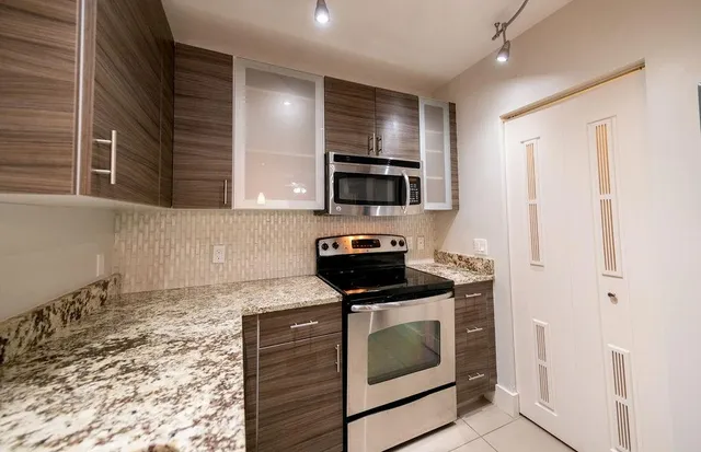 a kitchen with stainless steel appliances granite countertop a stove a microwave and a refrigerator