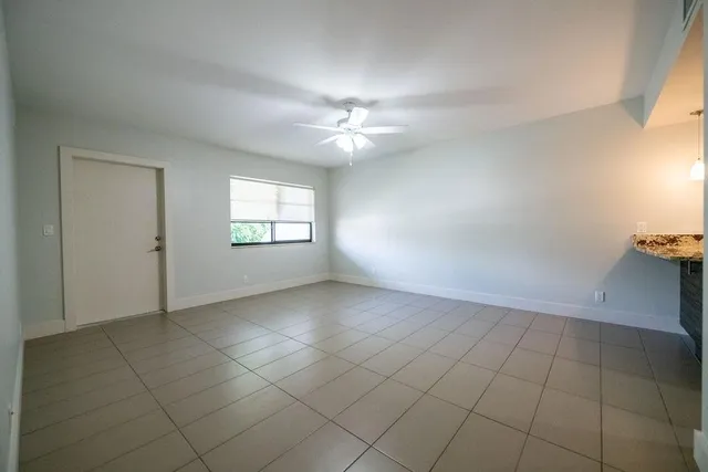 an empty room with windows and ceiling fan