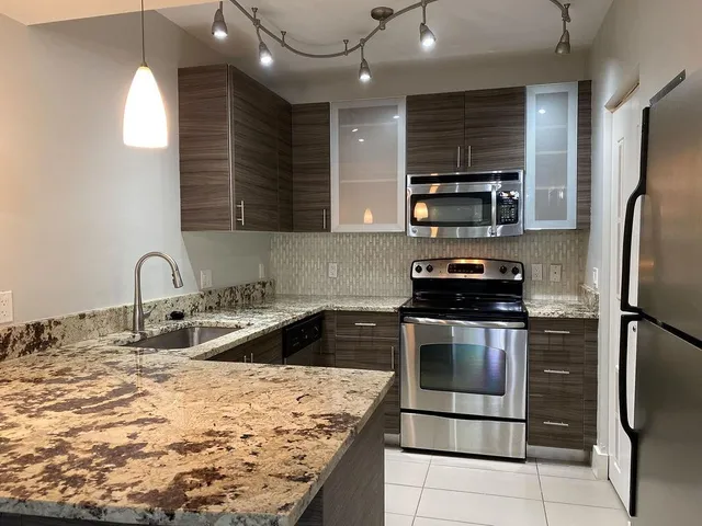 a kitchen with stainless steel appliances granite countertop a sink stove and refrigerator