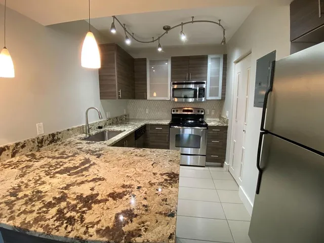 a kitchen with stainless steel appliances a refrigerator sink and microwave