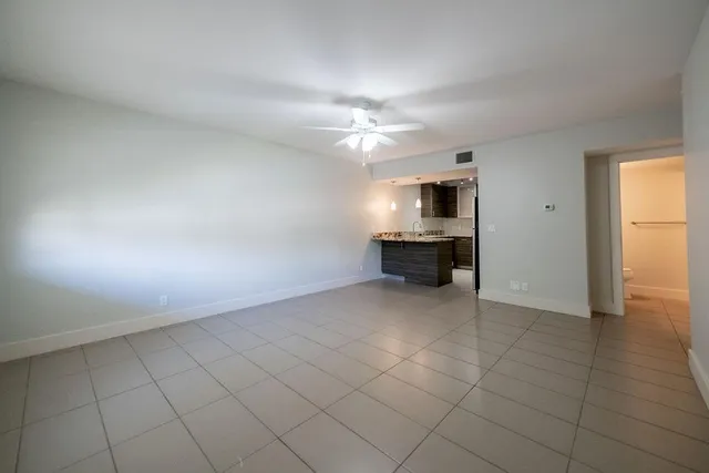 an empty room with a fireplace and windows