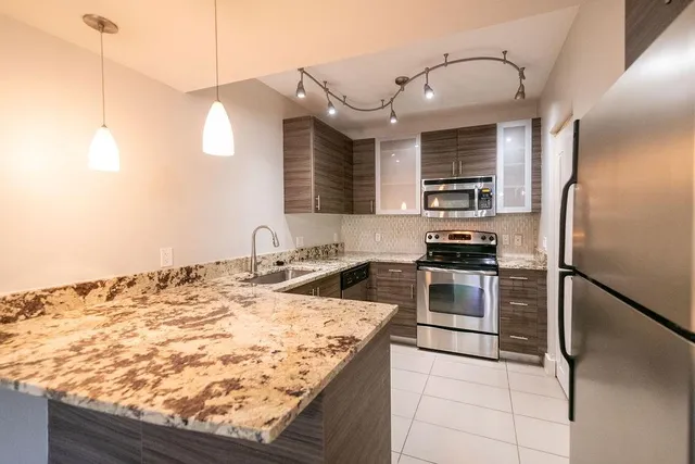 a kitchen with kitchen island a sink stainless steel appliances and counter space