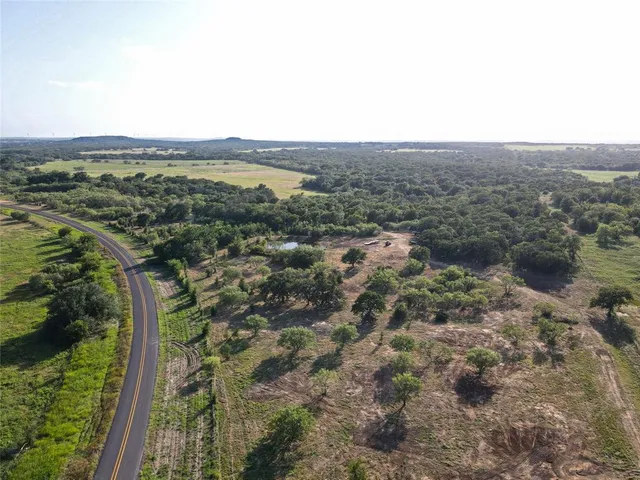 an aerial view of house with yard and mountain view in back