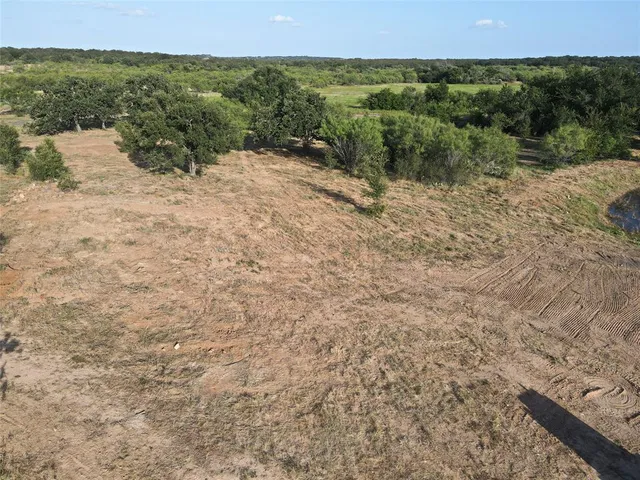 a view of a dry yard with wooden fence