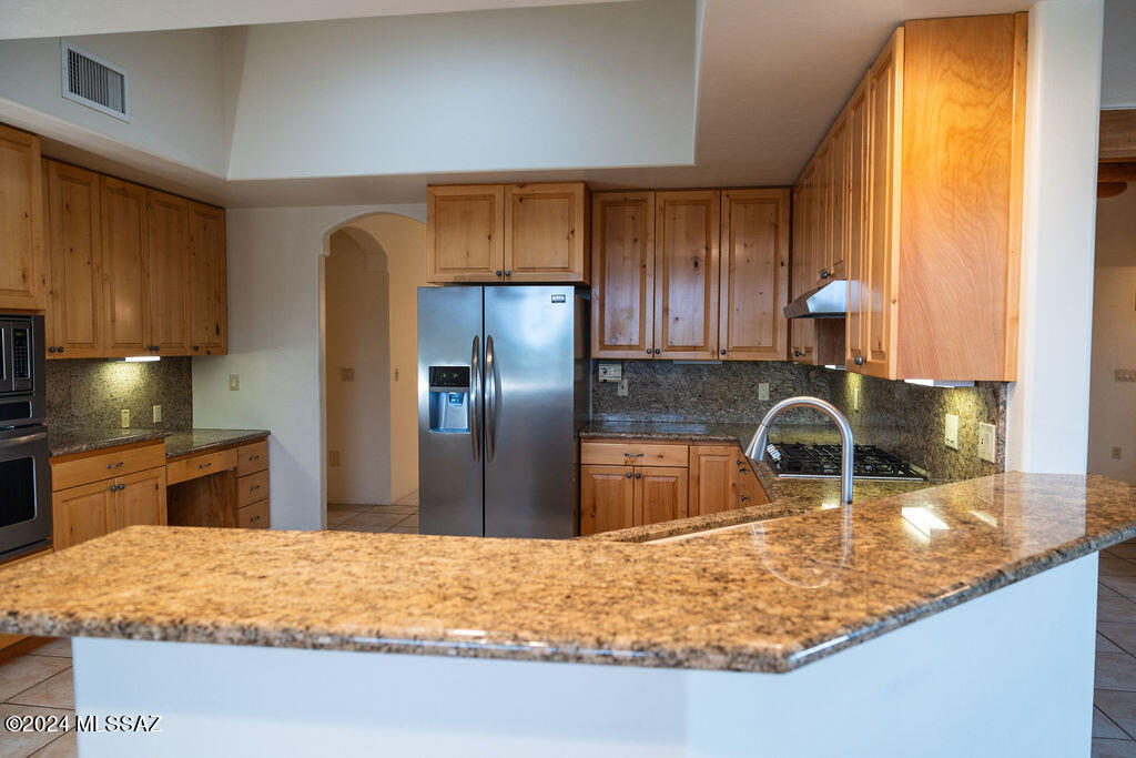 771 West Sedona Ridge Place Oro Valley, AZ 85755 - Photo 7 of 22 a kitchen with stainless steel appliances granite countertop a sink refrigerator and stove