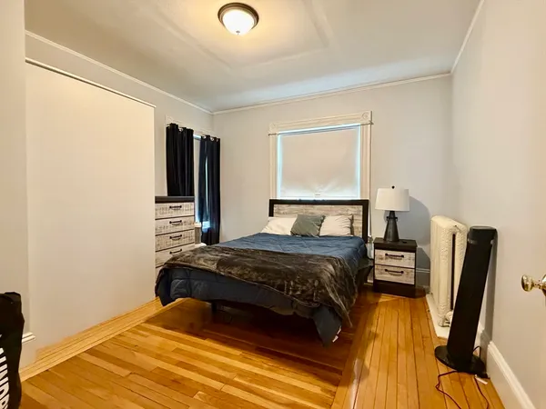 a bedroom with a bed and wooden floor