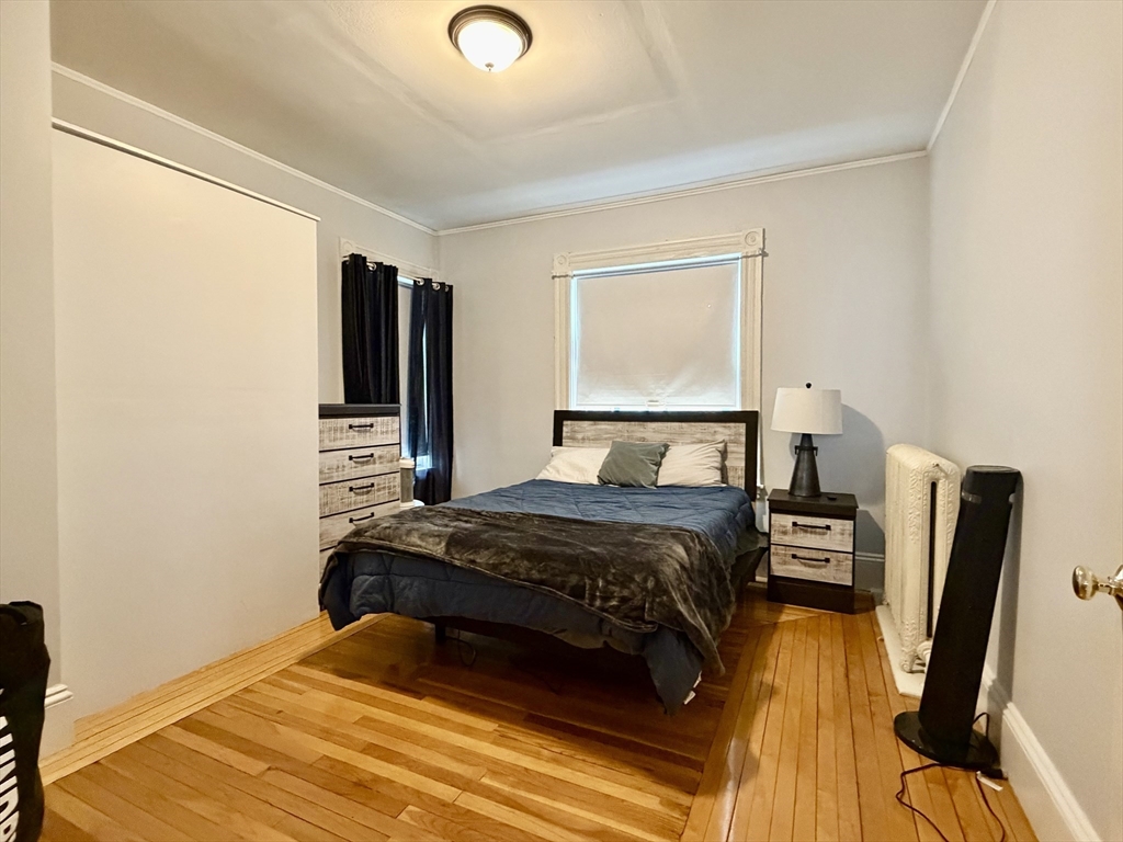 7 Judson Street, Unit 1 Beverly, MA 01915 - Photo 5 of 11 a bedroom with a bed and wooden floor