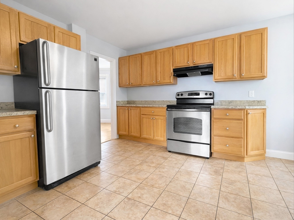 7 Judson Street, Unit 1 Beverly, MA 01915 - Photo 7 of 11 a kitchen with stainless steel appliances granite countertop a refrigerator sink and cabinets