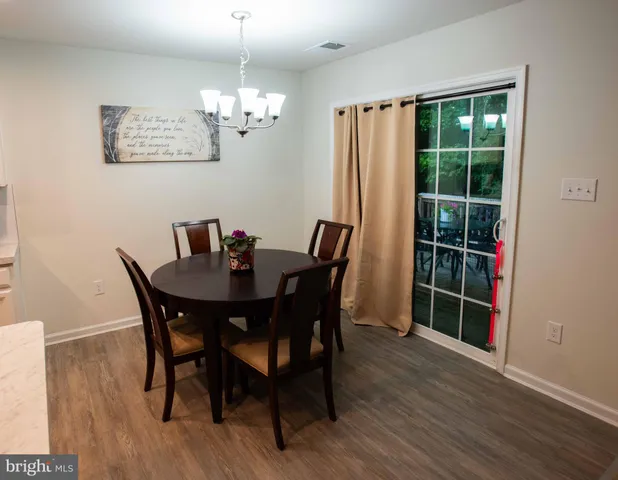 a view of a dining room with furniture wooden floor and chandelier