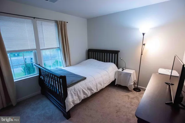 a bedroom with a bed next to a window