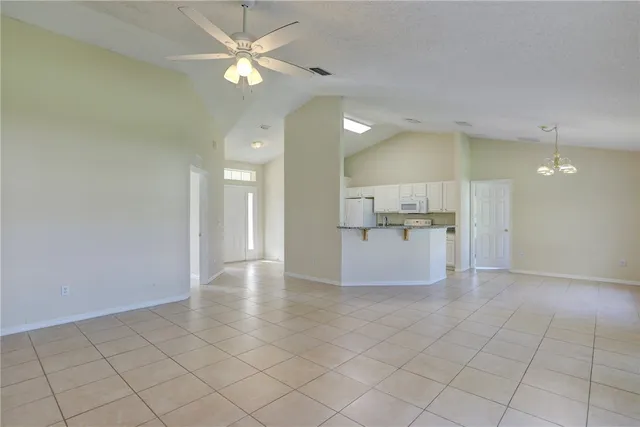 a view of a livingroom with a chandelier fan and windows