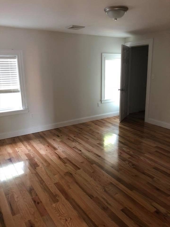 83.5 Market Street, Unit 83 5 Amesbury, MA 01913 - Photo 6 of 10 an empty room with wooden floor and windows