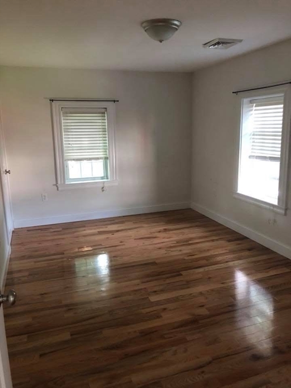 83.5 Market Street, Unit 83 5 Amesbury, MA 01913 - Photo 9 of 10 an empty room with wooden floor and windows
