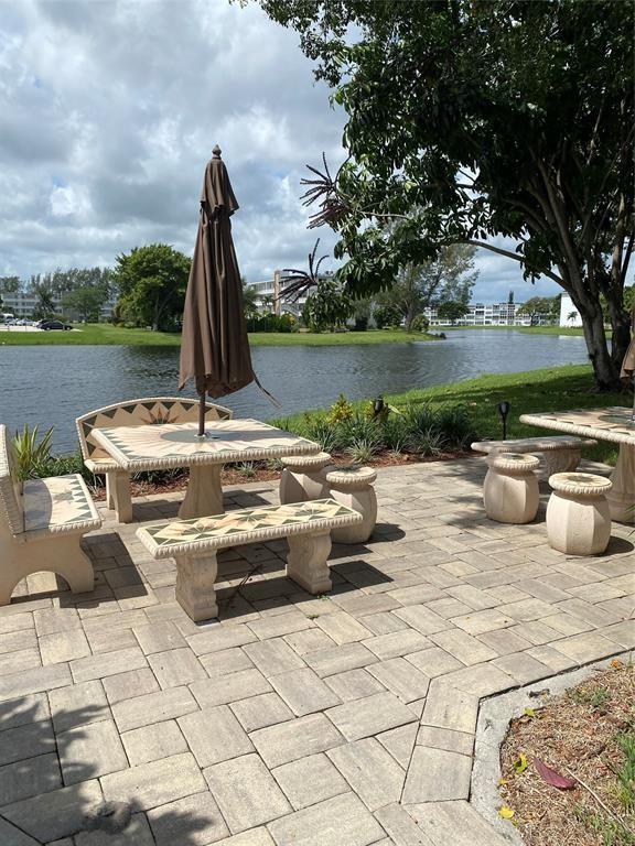 3012 Westbury F, Unit 3012 Deerfield Beach, FL 33442 - Photo 20 of 54 a view of a lake with couches chairs and a fire pit