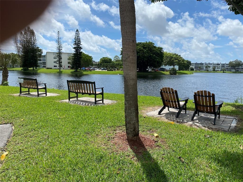 3012 Westbury F, Unit 3012 Deerfield Beach, FL 33442 - Photo 25 of 54 a view of a lake with table and chairs