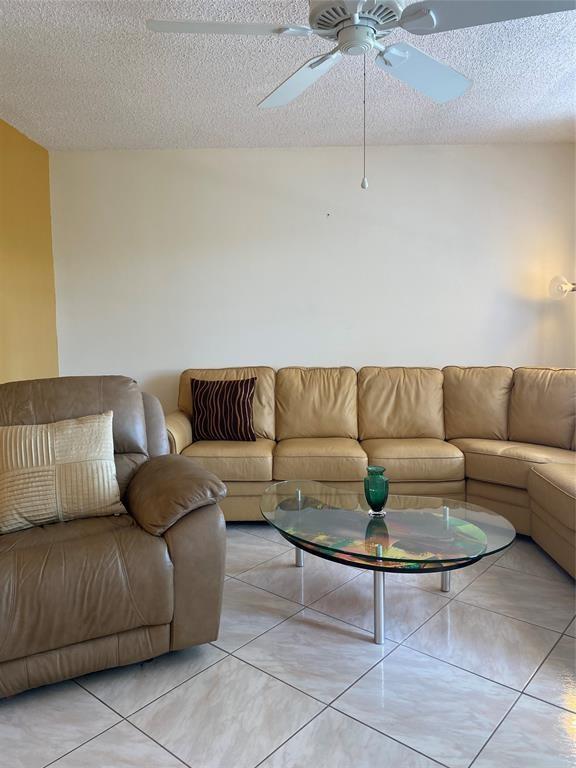 3012 Westbury F, Unit 3012 Deerfield Beach, FL 33442 - Photo 7 of 54 a living room with a couch and a coffee table
