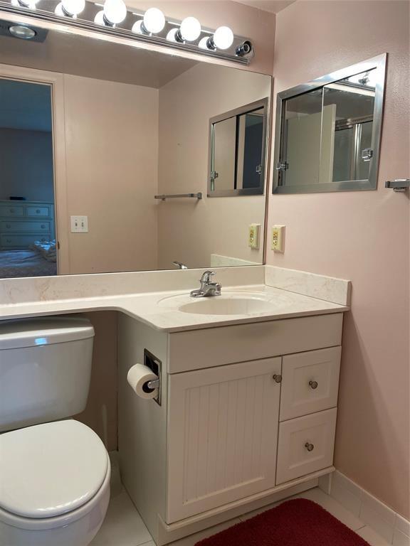3012 Westbury F, Unit 3012 Deerfield Beach, FL 33442 - Photo 9 of 54 a bathroom with a sink a toilet and mirror