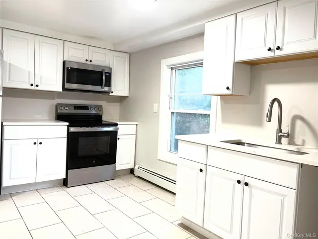 a view of a house with backyard and a tree