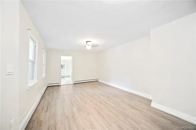 a view of a hallway with wooden floor and a chandelier