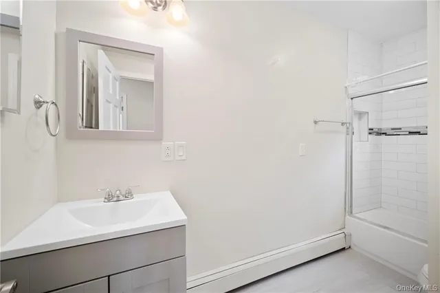 an empty room with wooden floor chandelier fan and windows