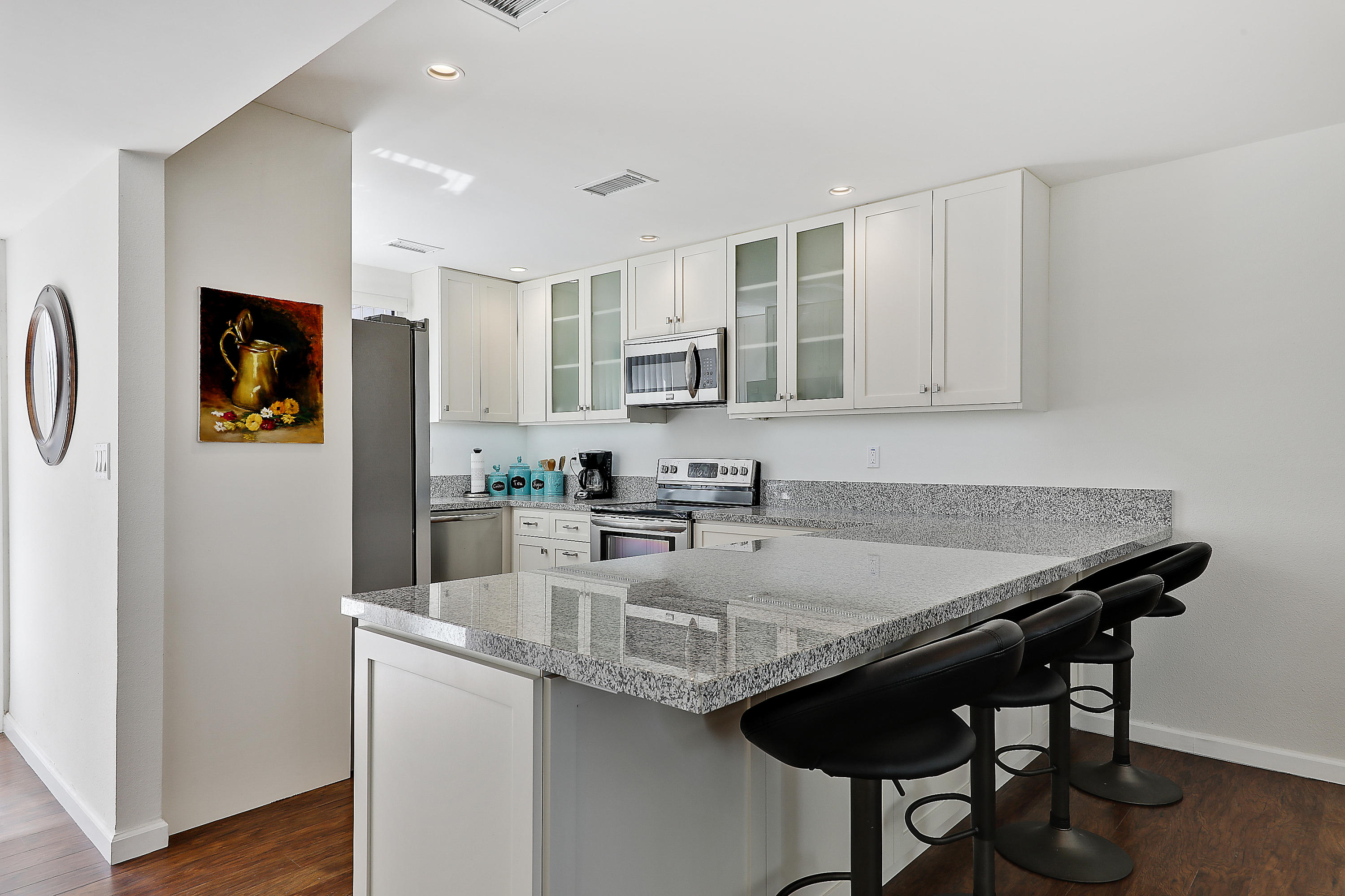 4 Leon Way Rancho Mirage, CA 92270 - Photo 1 of 20 a kitchen with granite countertop a stove a refrigerator and a refrigerator