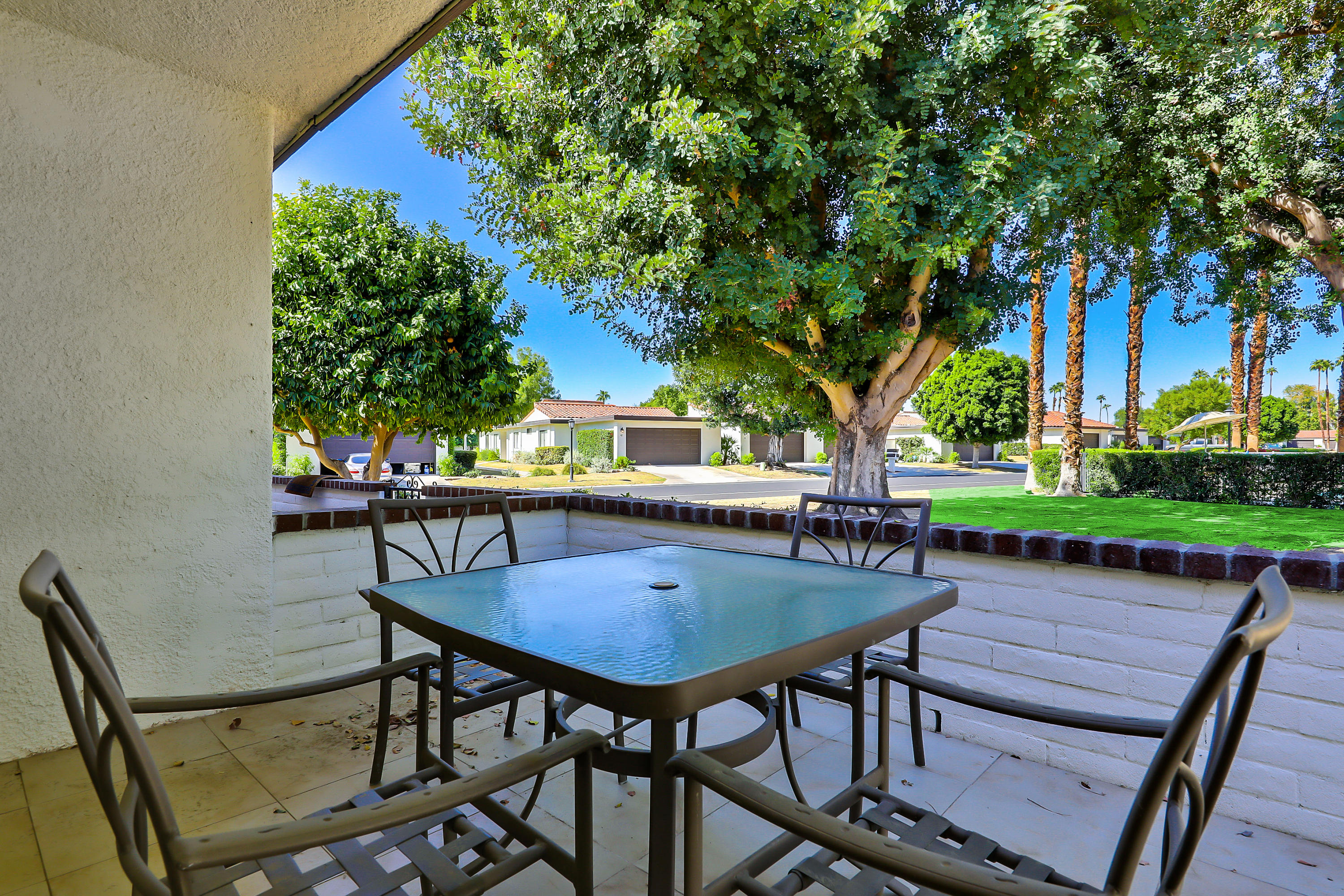 4 Leon Way Rancho Mirage, CA 92270 - Photo 17 of 20 a view of patio with table and chairs and potted plants with wooden fence