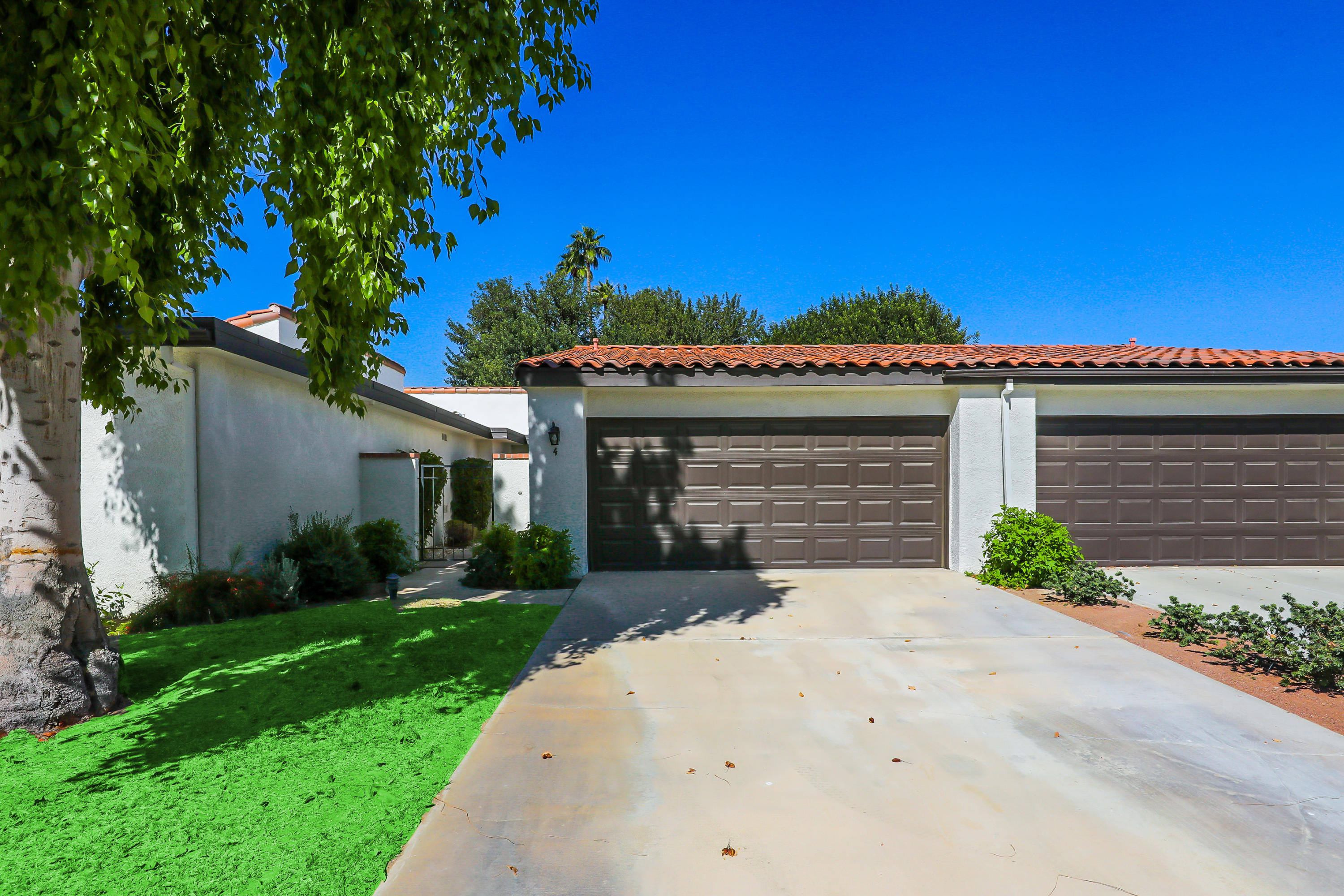 4 Leon Way Rancho Mirage, CA 92270 - Photo 18 of 20 a front view of a house with a yard and garage