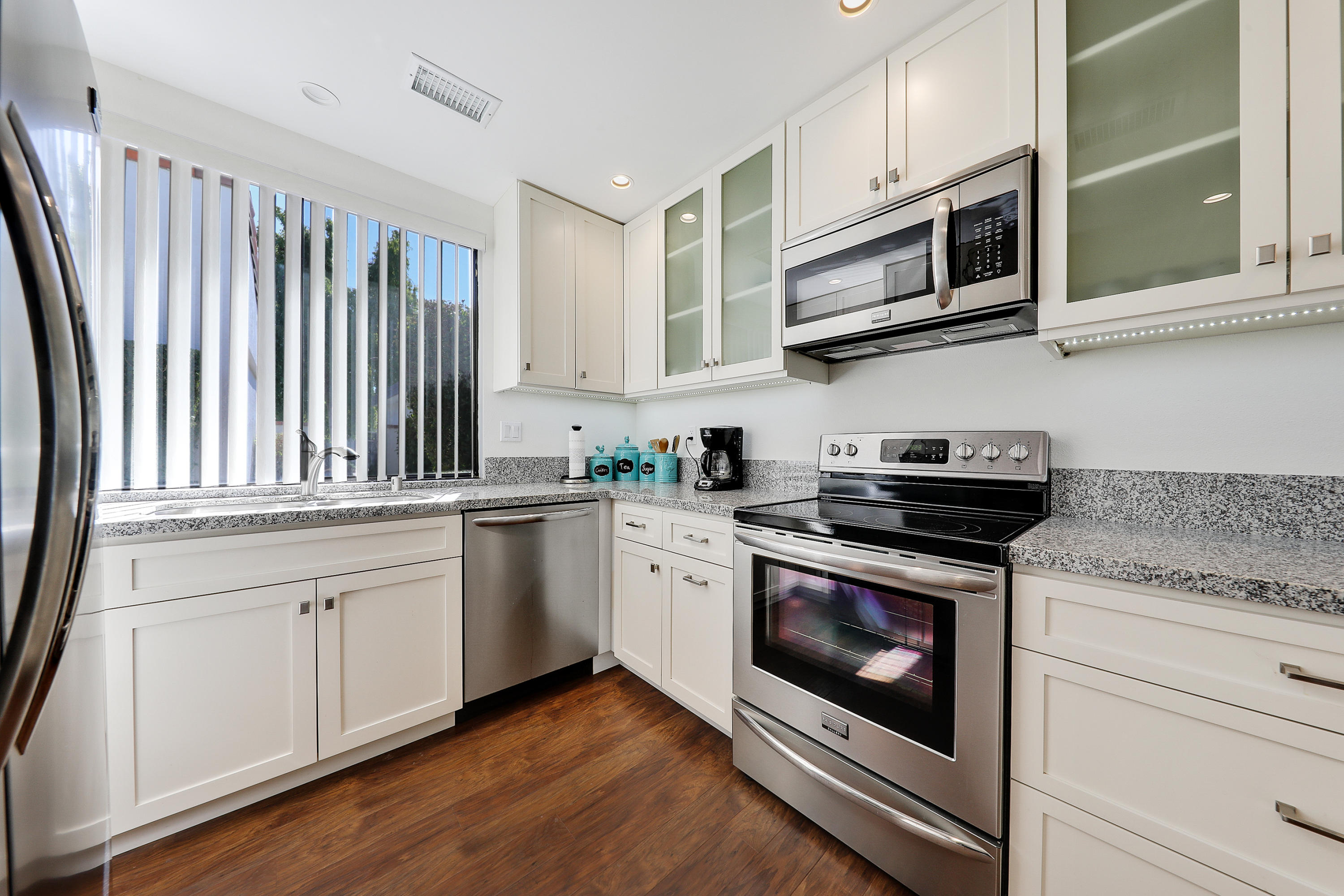 4 Leon Way Rancho Mirage, CA 92270 - Photo 3 of 20 a kitchen with stainless steel appliances granite countertop a stove a microwave and cabinets