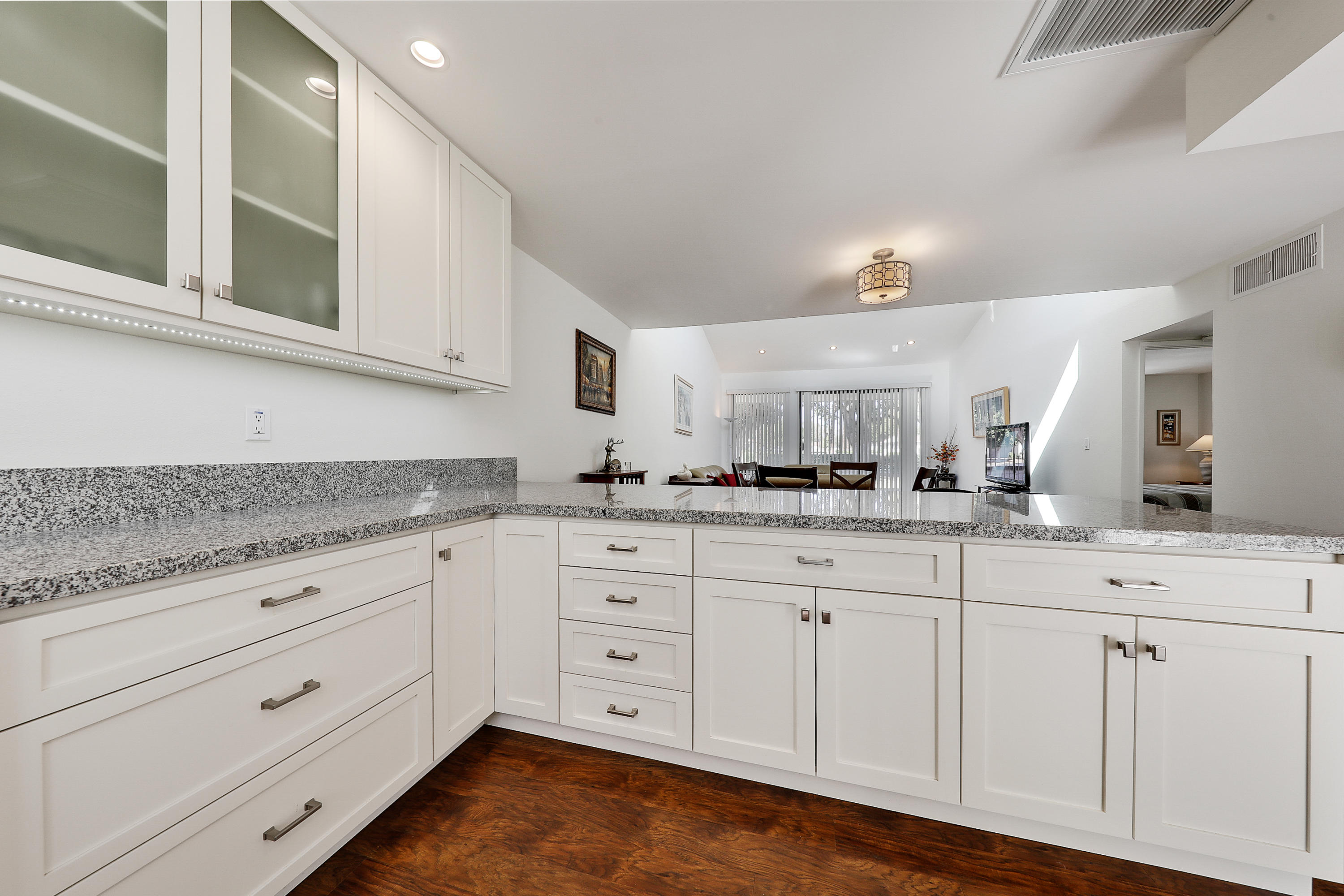 4 Leon Way Rancho Mirage, CA 92270 - Photo 4 of 20 a kitchen with granite countertop white cabinets and white appliances