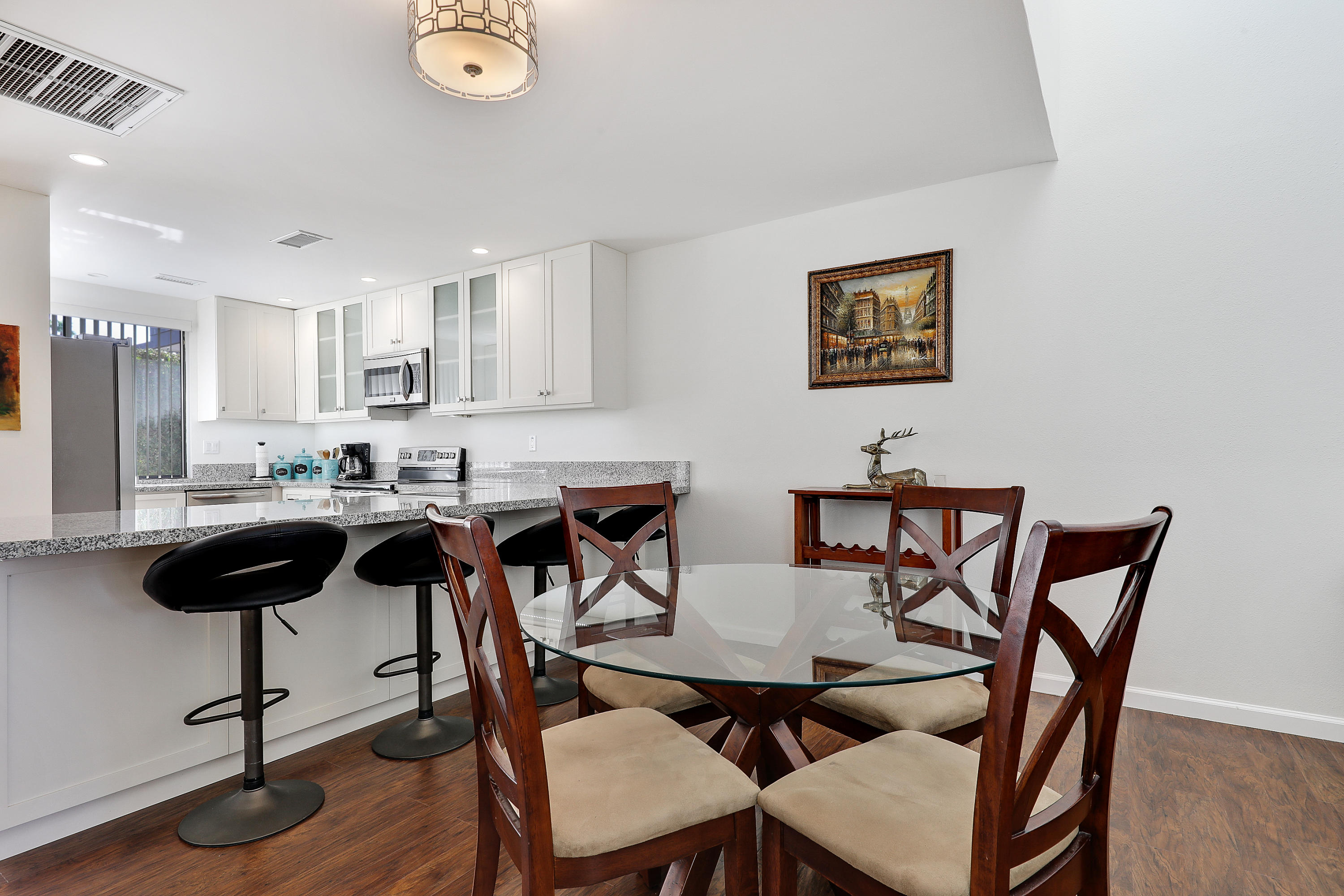 4 Leon Way Rancho Mirage, CA 92270 - Photo 5 of 20 a kitchen with a dining table and chairs